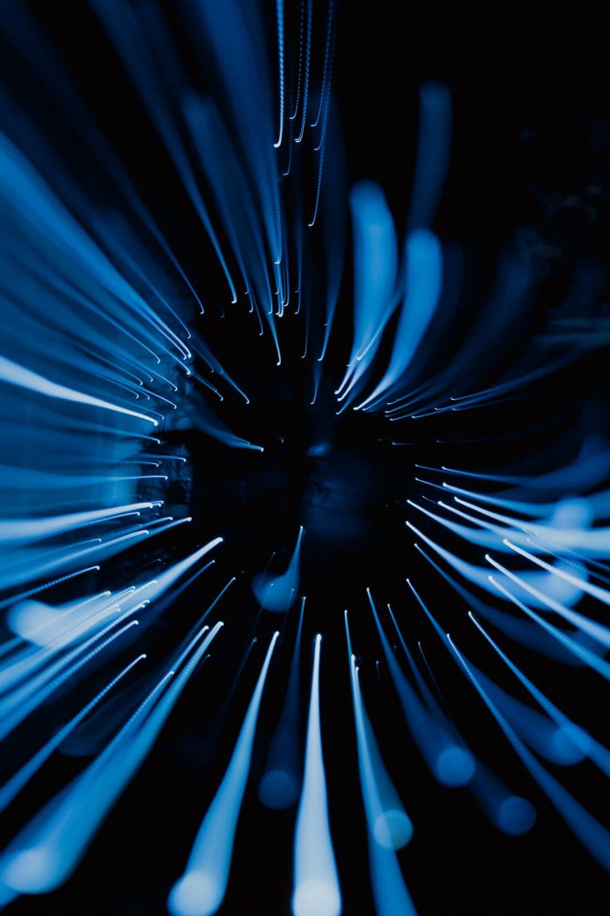 Des traînées de lumière bleue rayonnant sur un fond sombre